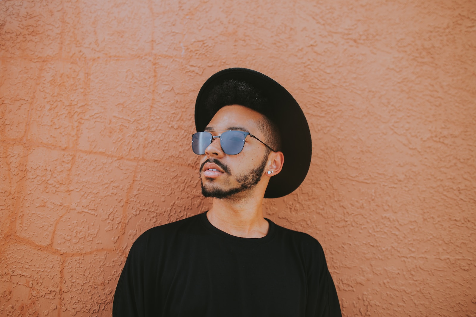 Photo by Ivana Cajina man leaning on brown wall