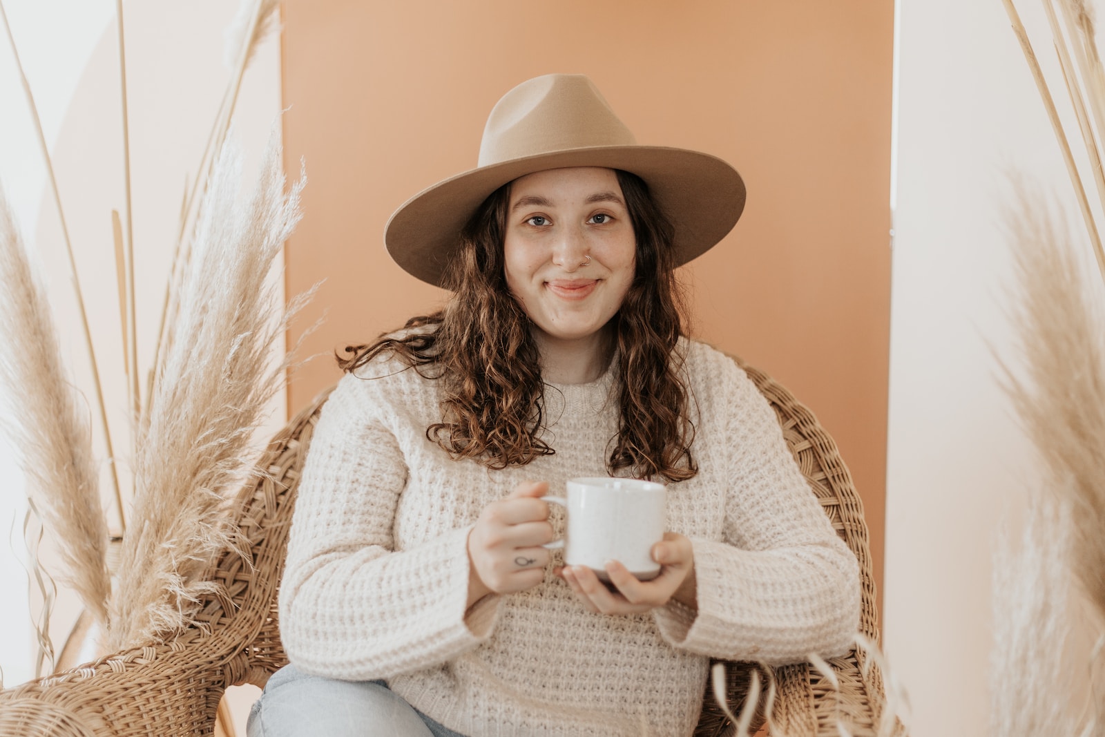 Photo by Madrona Rose woman in white knit sweater holding white ceramic mug